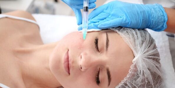 Ένας κοσμετολόγος εκτελεί μια διαδικασία αναζωογόνησης του δέρματος του προσώπου με πλάσμα